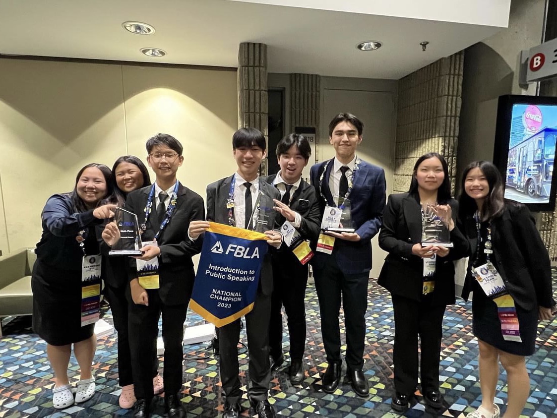 Eight of the nine FBLA NLC attendees proudly showcase their chapter badges and trophies after the awards ceremony (Photo by Michael Rylaarsdam)