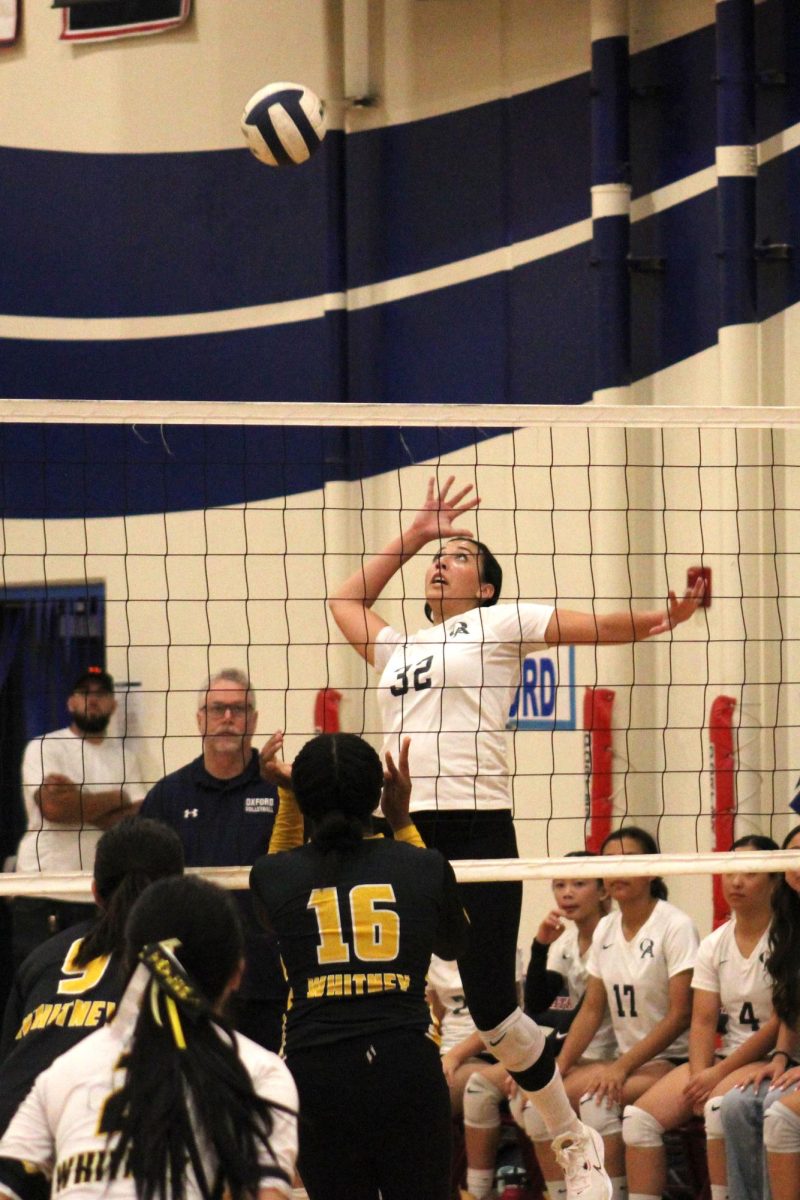 Team captain and senior Abbi Tago prepares to spike the ball over the net during Varsity Girls Volleyballs match against Whitney.