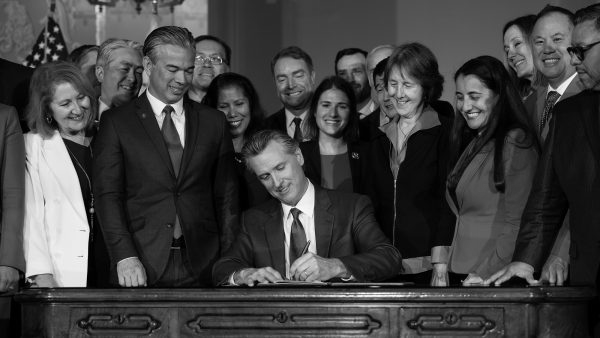 Making Change: California Governor Gavin Newsom is surrounded by lawmakers as he signs bills. (Photo by Miguel Gutierrez Jr.)