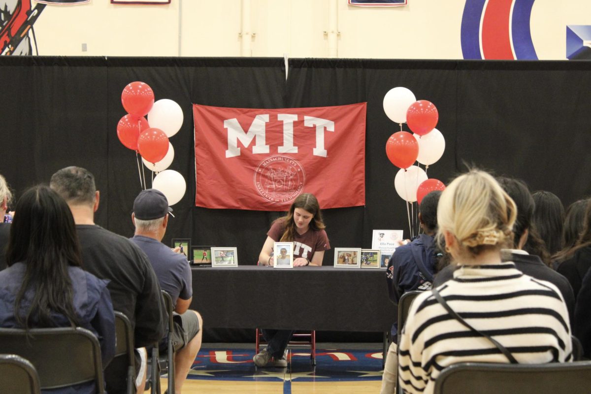 Sign away: Scholar athlete Ella Pace signs her contract with MIT softball in the Oxford Academy Gym on Apr. 3. (Photo by Cameron Oates) 