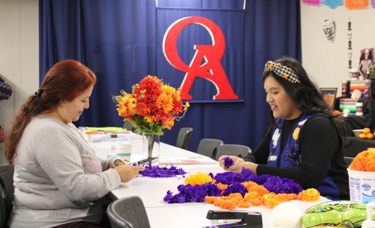 CREATING COMMUNITY: Oxford FACES Ms. Ortega and parent volunteer Zulema Limon build the ofrenda. 