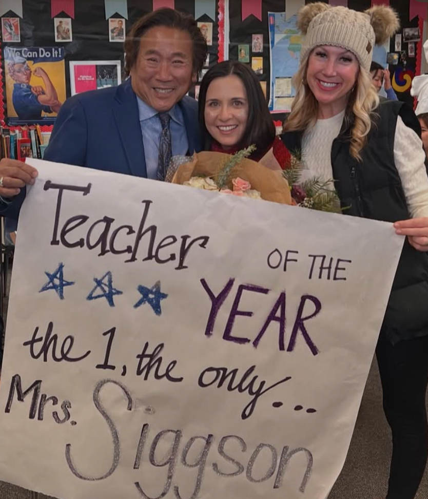 HONORABLE AWARD: Mrs. Siggson (middle) poses with AUHSD Trustee Ron Hoshi (left) and Principal Houston (right), holding up her surprise poster and flowers celebrating her award. 