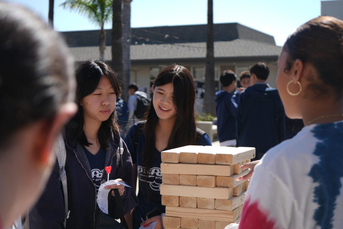 Jasmine Nguyen (10), Lynn Huynh (10), and Julissa Boykin (12) celebrate BSU's Black History Week with trivia-themed Jenga in the quad. (Photo by Tyler Nguyen)