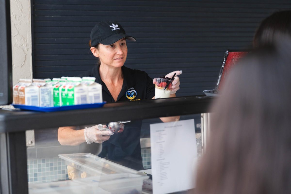 PARFAIT PERFECTION: Mrs. Camarillo warmly hands a student a custom-made cup of yogurt at the new parfait bar.