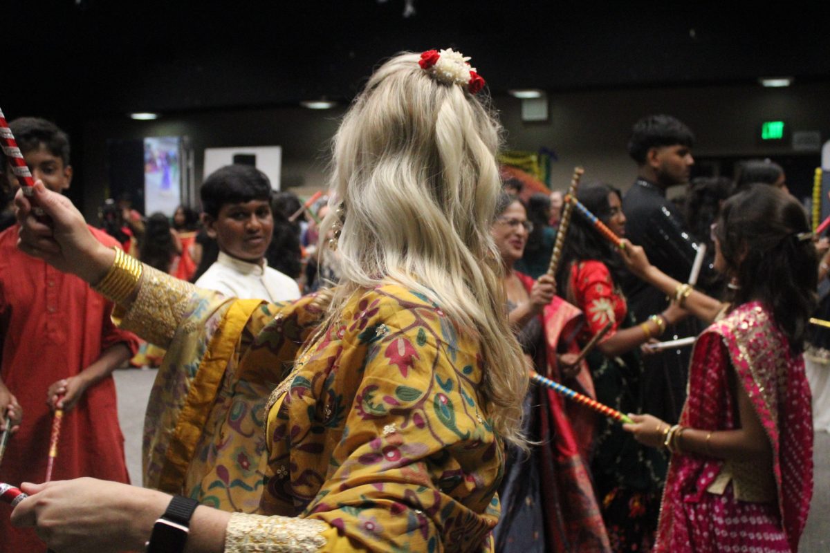 DANCING WITH STUDENTS: Principal Houston embraces the spirit of Garba Night by taking part in the dandiya circle.