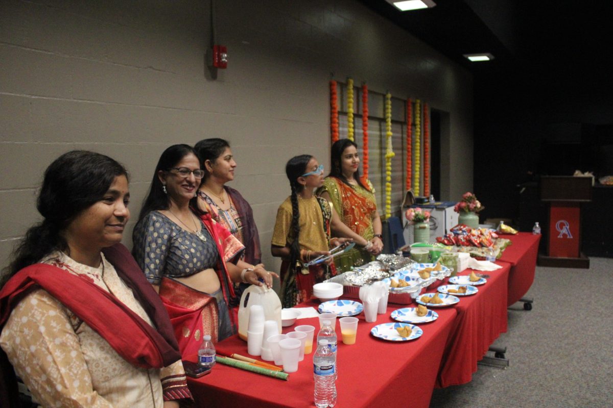 FUELING THE FUN: Volunteers and students work together to serve samosas and mango lassi during the event while admiring participation on the dance floor